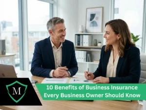 Two smiling business professionals reviewing financial charts and documents at an office desk.
