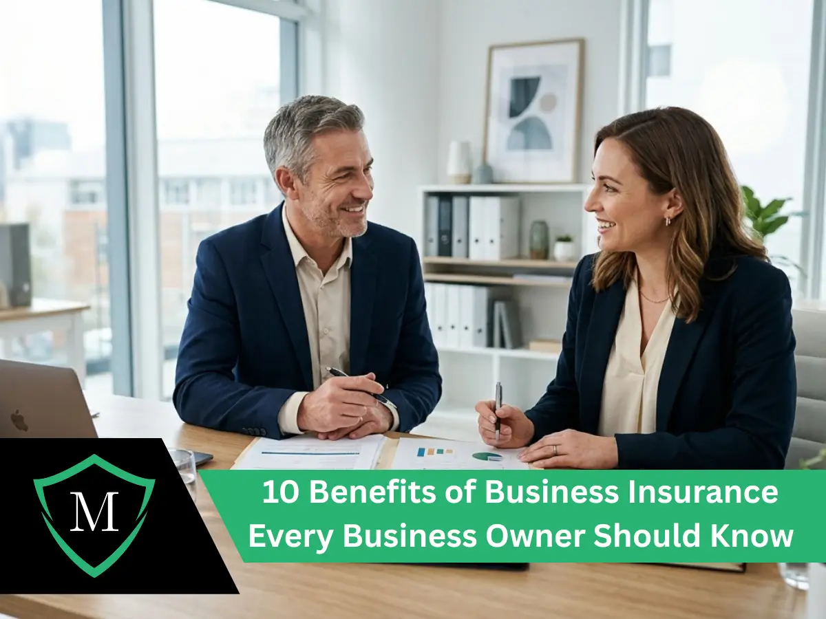 Two smiling business professionals reviewing financial charts and documents at an office desk.